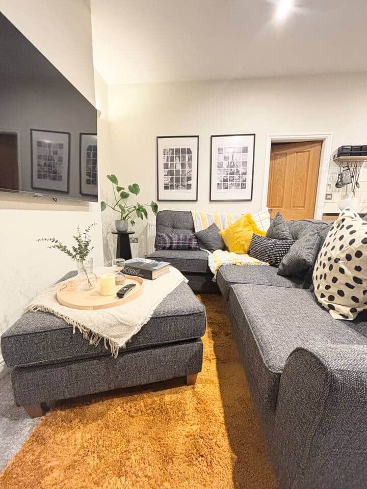 Spacious lounge with grey seating in Apartment 2